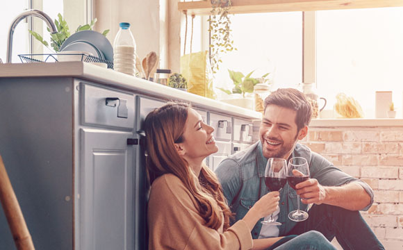 joven pareja tomando algo en la cocina de casa