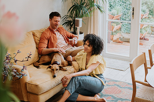 Dos personas y un perro conversando en el salón