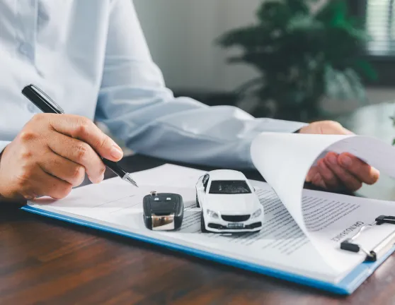 Persona leyendo y firmando un documento del coche