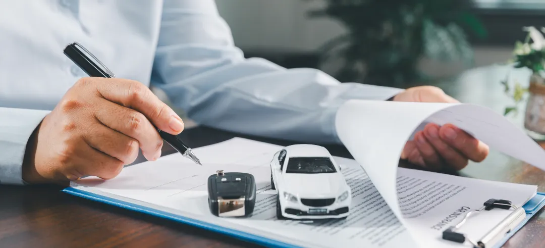 Persona leyendo y firmando un documento del coche