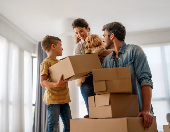 Familia con hijo, perro y cajas de mudanza