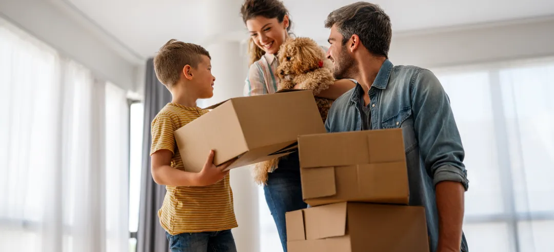 Familia con hijo, perro y cajas de mudanza