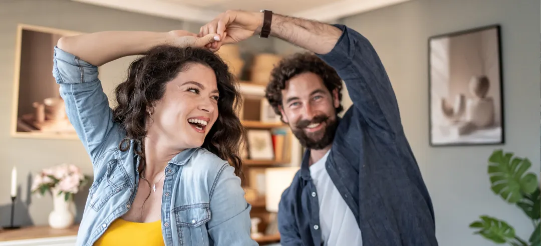 Pareja bailando y riéndose en casa