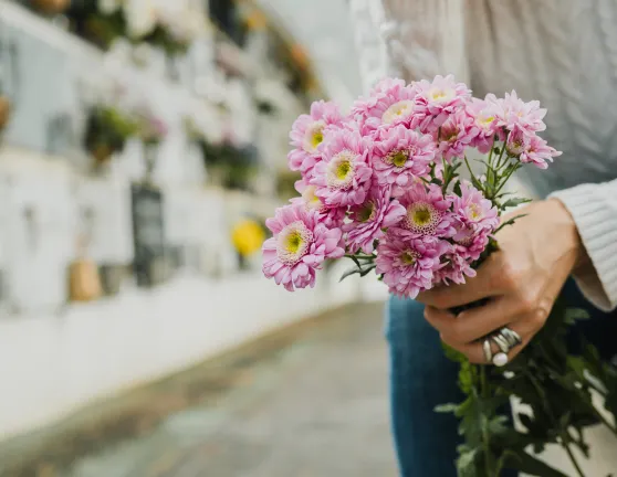 Persona con flores sentada en un cementerio