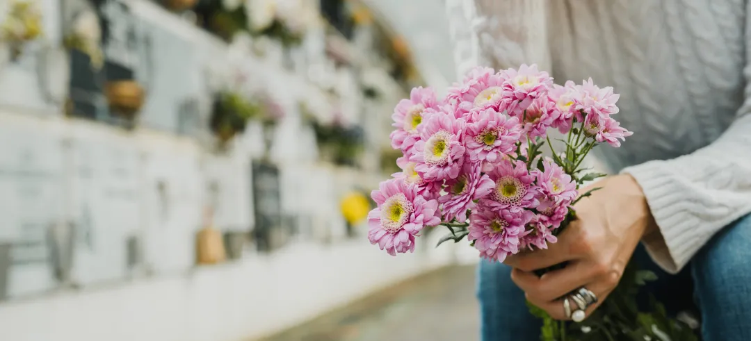 Persona con flores sentada en un cementerio