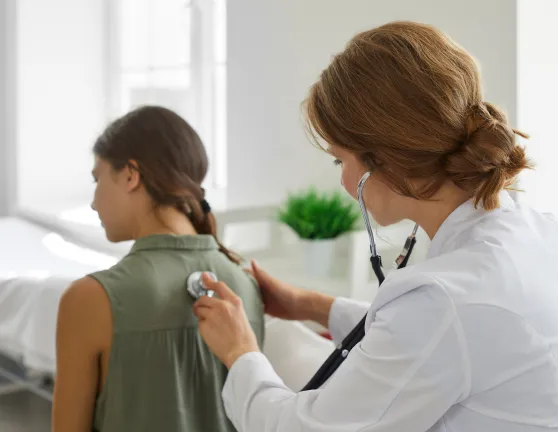 Médica auscultando a una paciente
