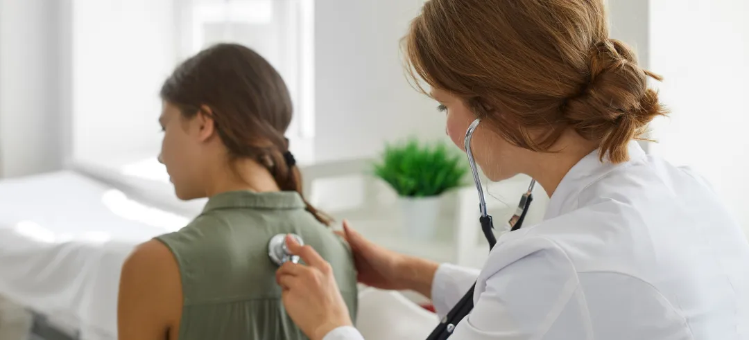 Médica auscultando a una paciente