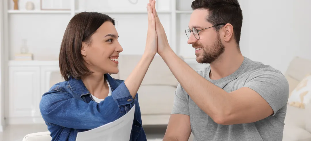 Pareja chocando las manos revisando papeles