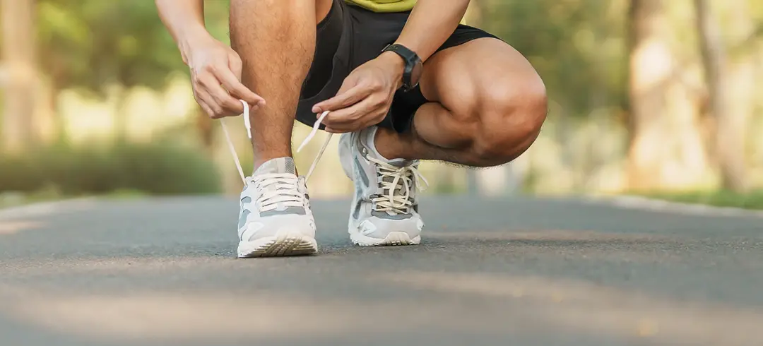 corredor abrochándose las deportivas