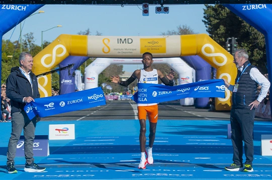 Corredor cruzando la línea de meta Zurich Maratón Sevilla
