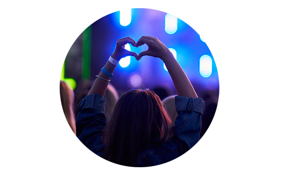 persona en un concierto haciendo un corazón con la mano