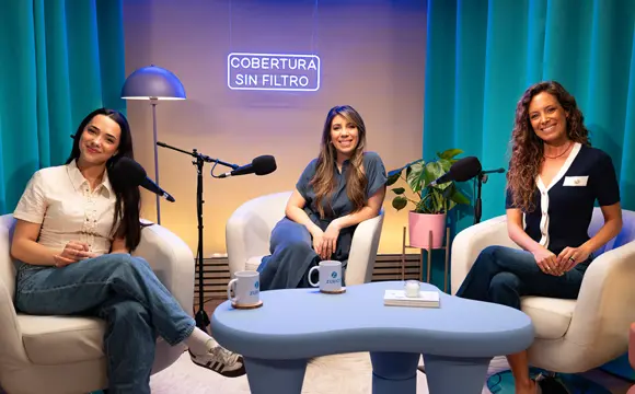 dos mujeres y una adolescente sonrientes con un micrófono