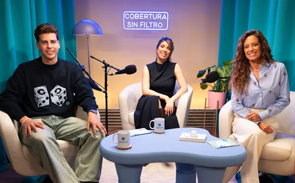 dos mujeres y un adolescente sonrientes con un micrófono