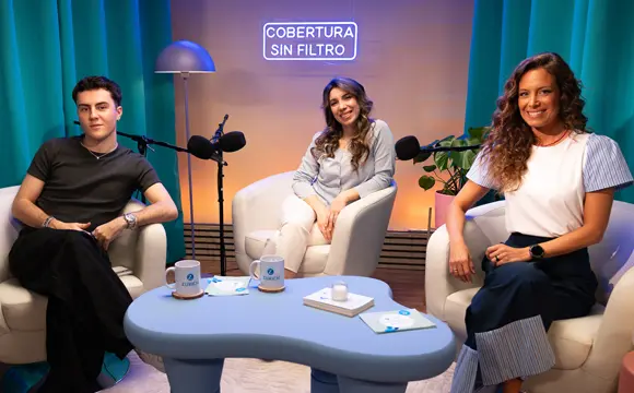 dos mujeres y un adolescente sonrientes con un micrófono