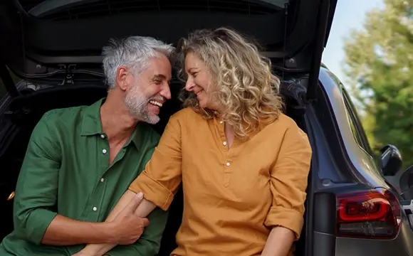 pareja sentada en el maletero del coche