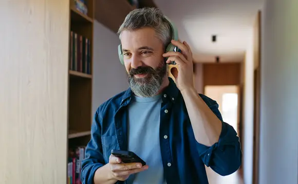 señor escuchando música en casa