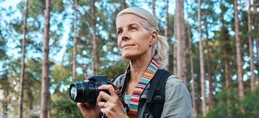 señora haciendo fotos en un bosque
