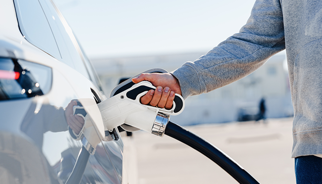 persona recargando coche eléctrico