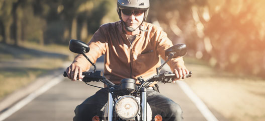 primer plano de un chico en una moto custom