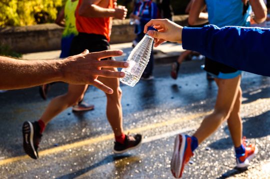 corredores recibiendo una botella de agua
